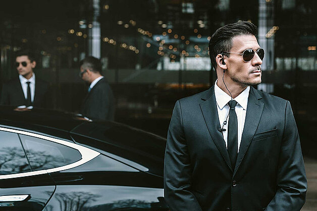 close protection officer waiting at vehicle